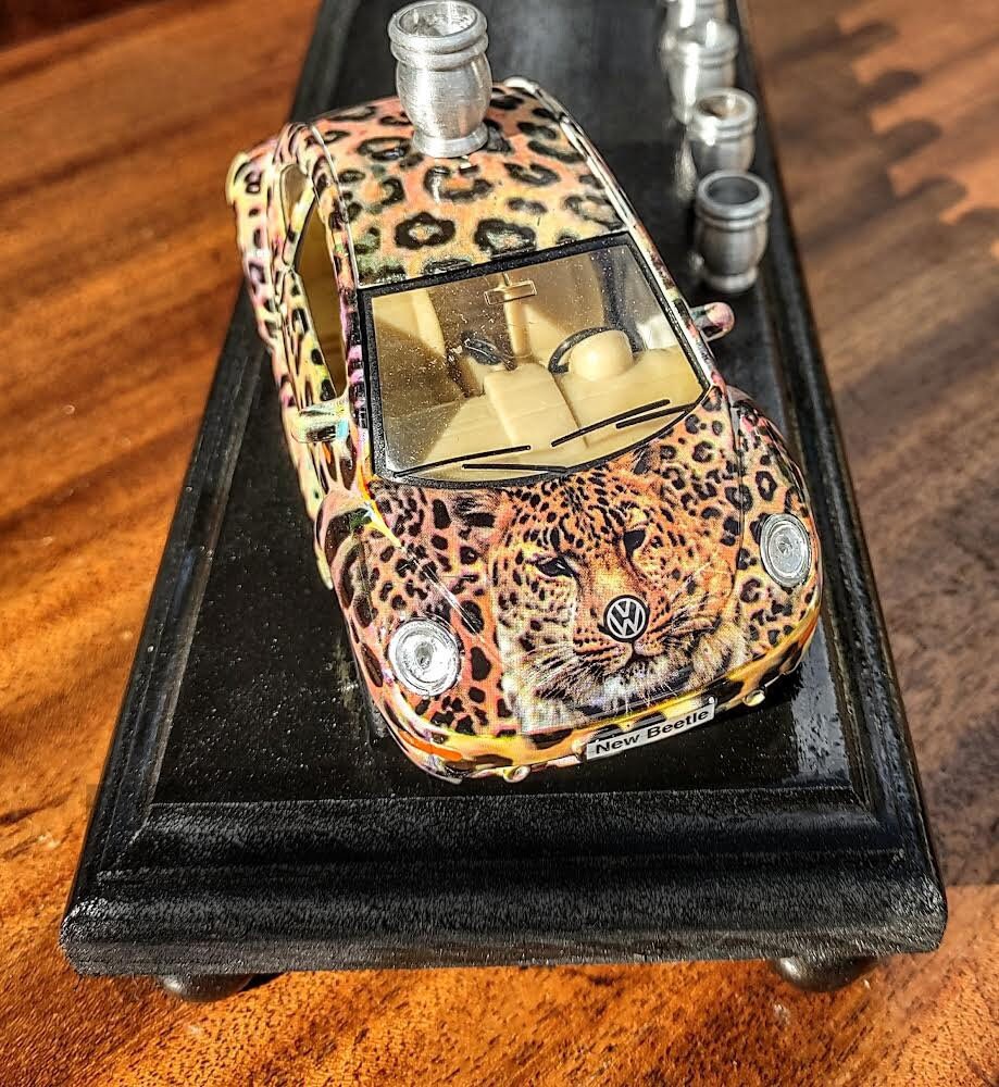 Punch-buggy menorah — leopard-print die-cast VW beetle on a painted wood base with candle cups | Judaica Square Lake (view 3)