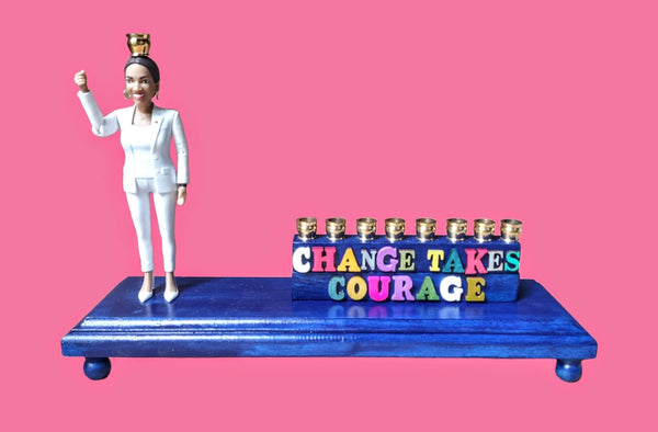 Senator AOC menorah — action figure raising the shamash beside carved wood letters | Judaica Square Lakewood
