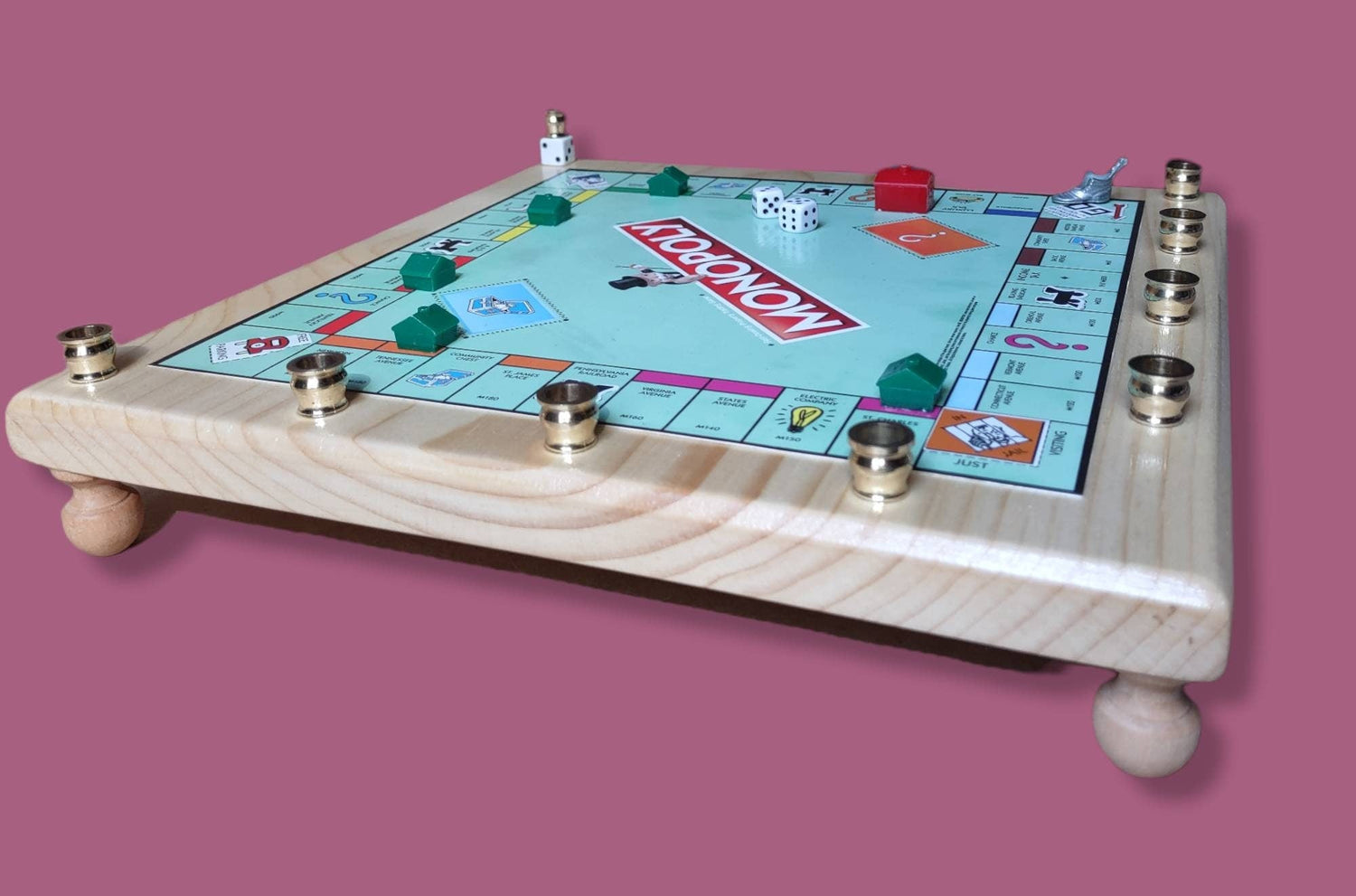 Monopoly menorah — repurposed game board and tokens on stained wood with brass cups | Judaica Square Lakewood (view 2)