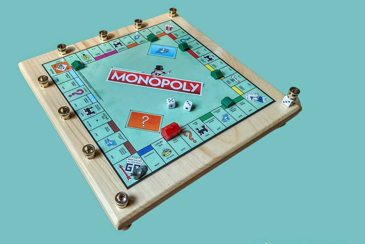 Monopoly menorah — repurposed game board and tokens on stained wood with brass cups | Judaica Square Lakewood (view 4)