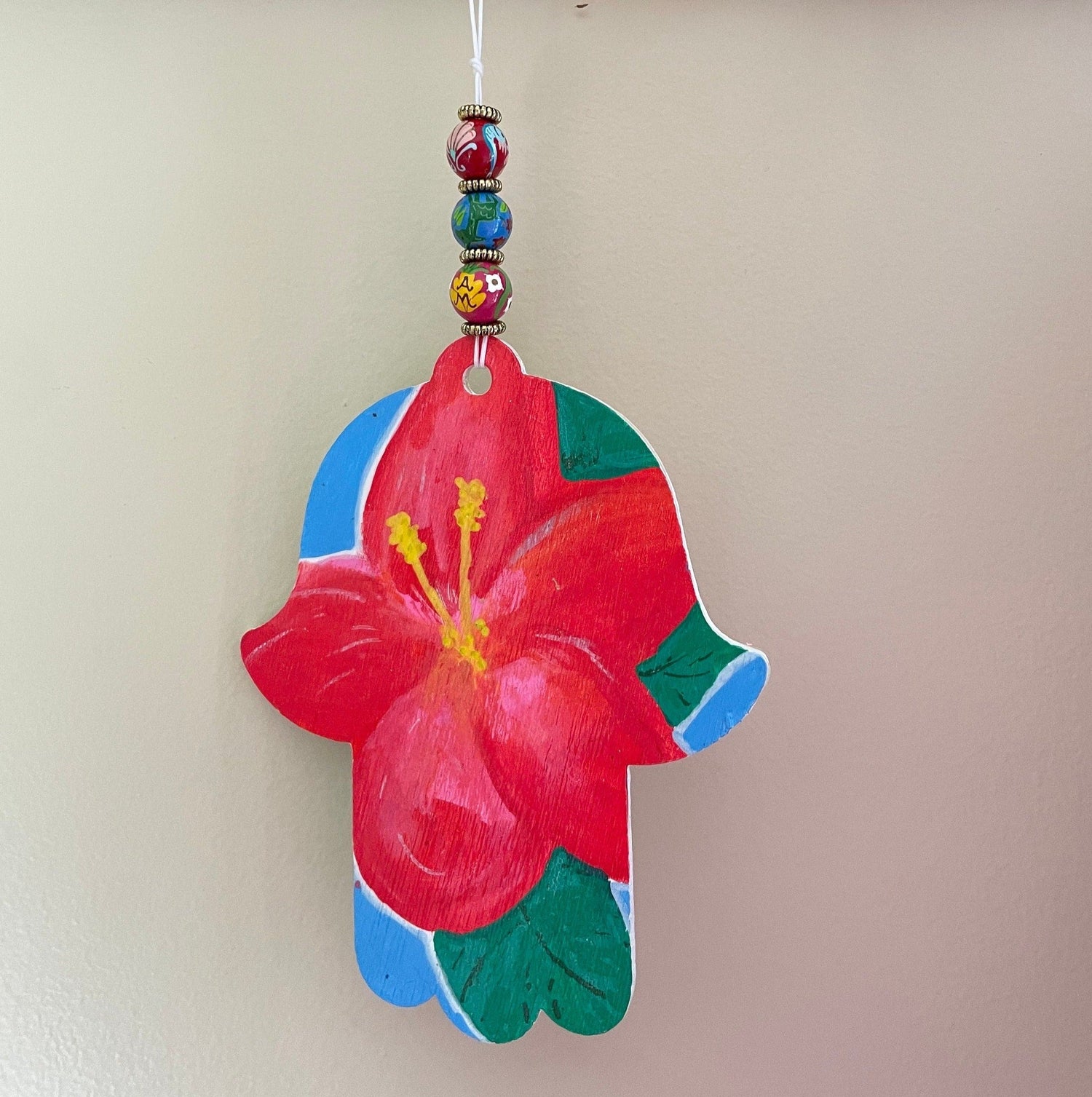 Hibiscus hamsa — painted wood hand on cotton string with wooden beads | Judaica Square Lakewood (view 3)