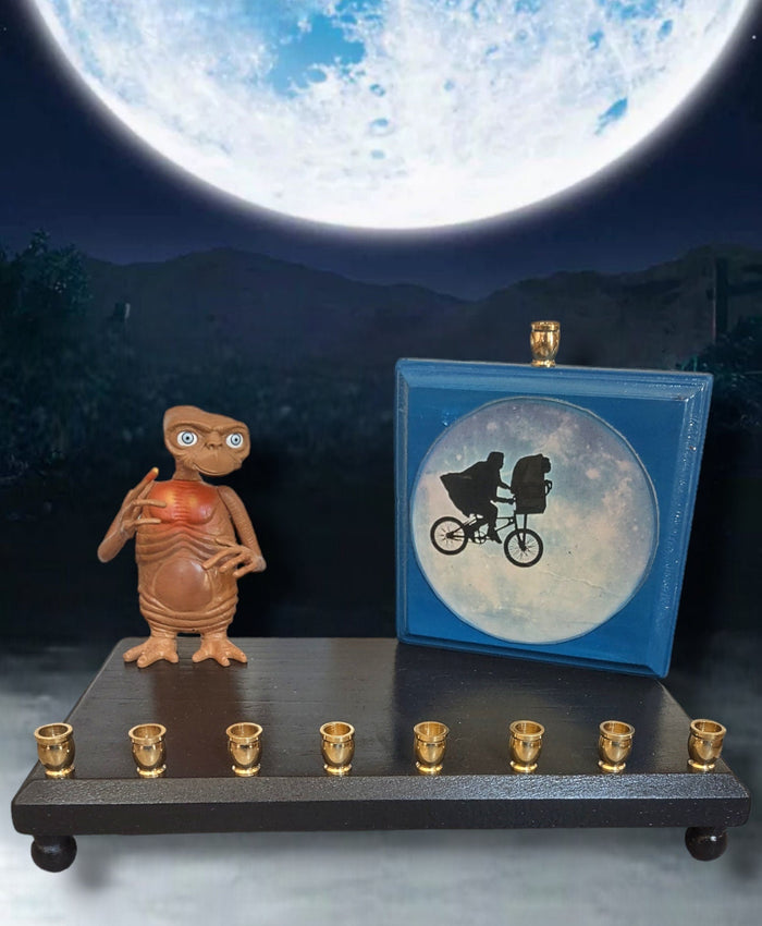 E.T. silhouette collector menorah — figure in front of a painted silhouette plaque | Judaica Square Lakewood