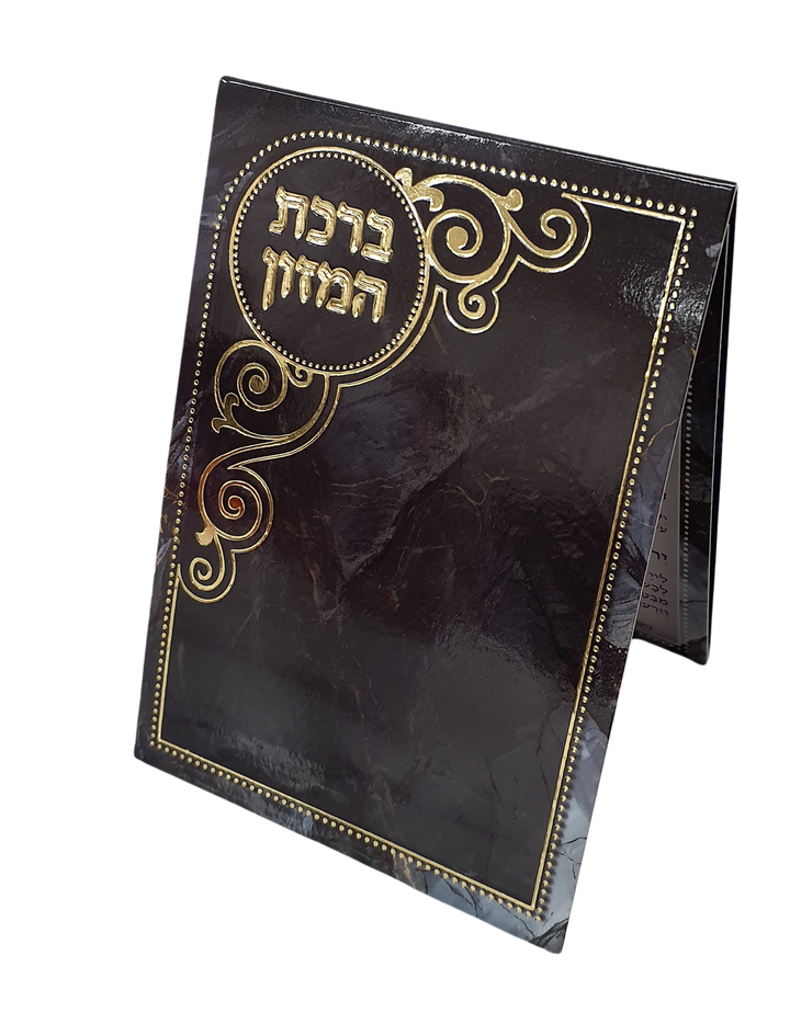 Three-fold pocket bencher standing partly open, black marble-look cover with Birchat Hamazon in gold foil inside a round medallion and gold scroll ornaments