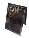 Three-fold pocket bencher standing partly open, black marble-look cover with Birchat Hamazon in gold foil inside a round medallion and gold scroll ornaments