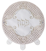 Round matzah cover with a blush quilted faux-leather border set with crystals, white velvet center embroidered Pesach in silver scrollwork and three labeled pocket tabs at the lower edge