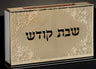 Gold engraved match box cover with black Shabbat Kodesh lettering and scrollwork corners