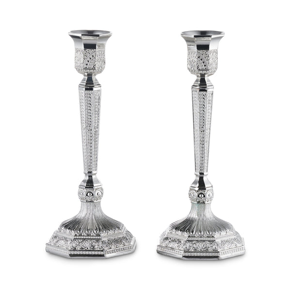 Two silver-plated filigree candlesticks with tapered engraved stems and octagonal bases