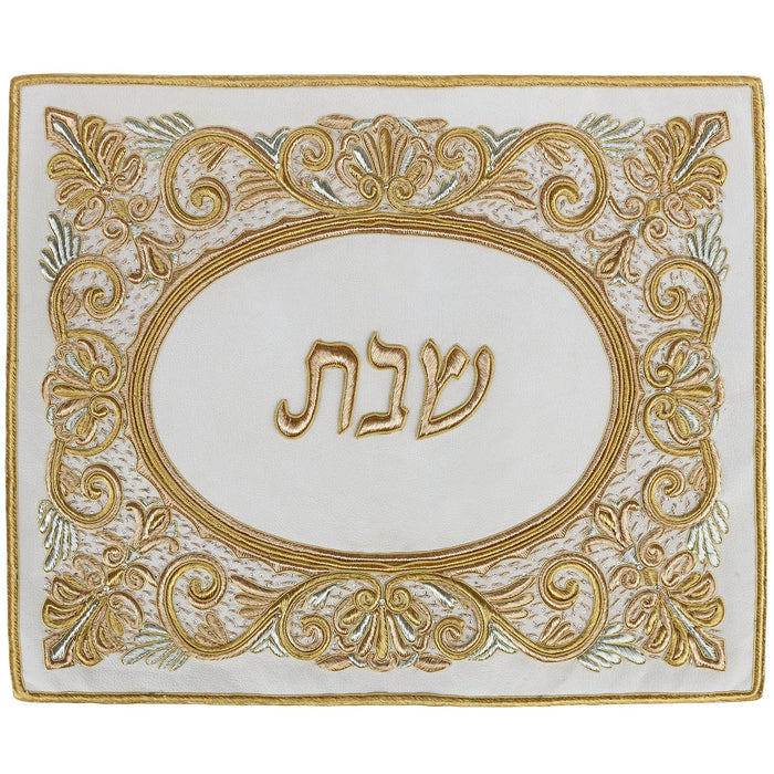 Cream suede challah cover with raised gold scroll embroidery around a gold Hebrew Shabbos oval
