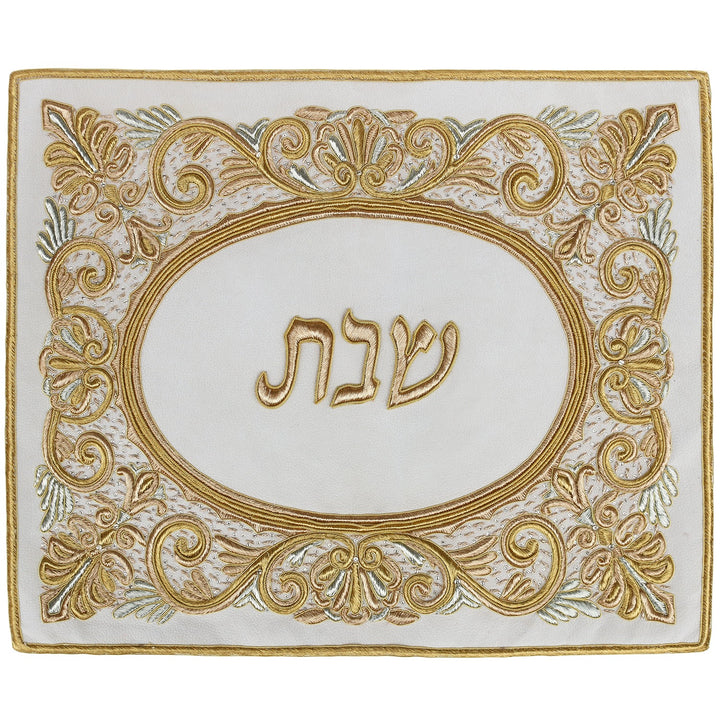 Cream suede challah cover with raised gold scroll embroidery around a gold Hebrew Shabbos oval