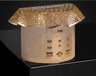 Round gold-tone tzedakah box with 770 building facade and lattice-cut roof lid, on a black surface