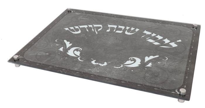 Gray marble-look glass challah board on small legs, lettered Lichvod Shabbat Kodesh in white Hebrew
