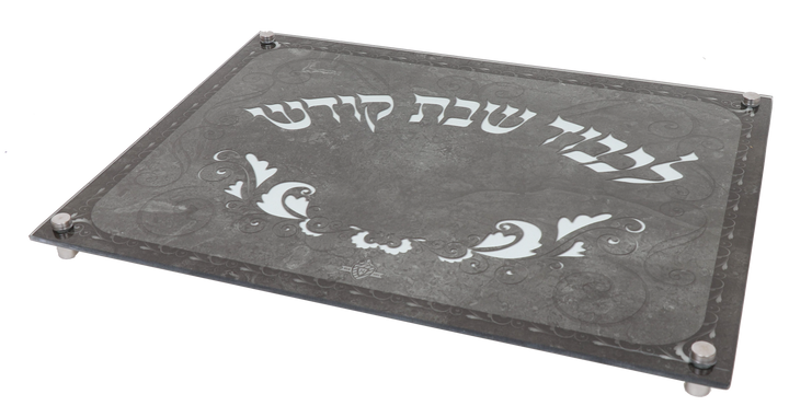 Gray marble-look glass challah board on small legs, lettered Lichvod Shabbat Kodesh in white Hebrew