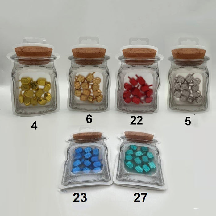 Six jar-shaped pouches of small metal dreidels in gold, bronze, red, silver, blue and teal