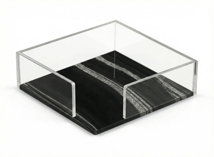 Square napkin holder with clear sides on a black base streaked with sparkling silver