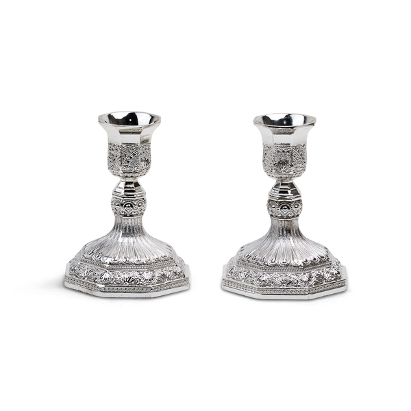 Two short silver-plated filigree candlesticks with octagonal cups and wide octagonal bases