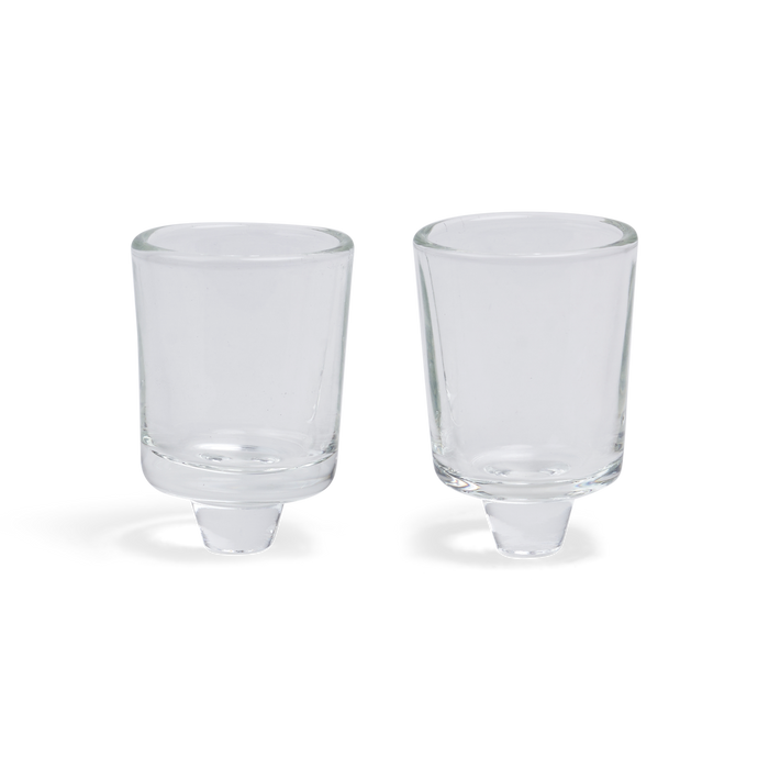 Two clear glass neronim cups with short peg bases, side by side