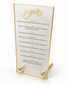 Frosted acrylic simanim card with a gold rim standing on two gold ball-footed legs, raised gold cursive heading at the top and the Yehi Ratzon for each siman printed below in Hebrew