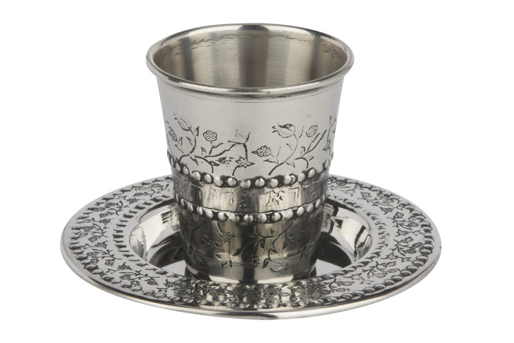 Stainless steel kiddush cup with etched pomegranate branches on a matching decorated plate