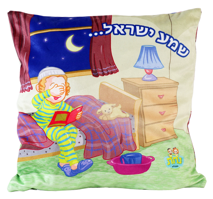 Square plush pillow printed with a cartoon boy in striped pajamas covering his eyes on his bed, Shema Yisrael in blue Hebrew above, a plush lamb, bedside lamp and a washing cup and bowl on the floor