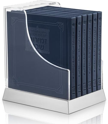 Navy faux-leather interlinear zemiros set of six volumes in a lucite case, each 6 inches square.