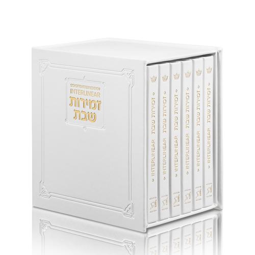 White faux-leather zemiros with gold trim, a six-volume interlinear set of 6 by 6 inch books.
