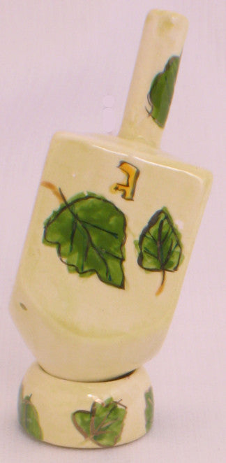 Karshi ceramic dreidel painted with green leaves on a cream ground with matching stand
