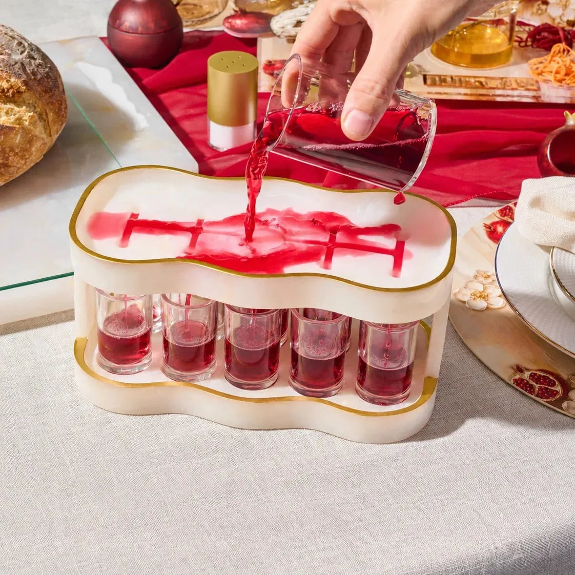 Curved Kiddush fountain set with ten cups filled for serving wine