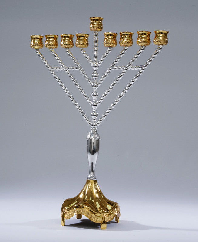 Large menorah with slender silver arms, gold cups, a raised shamash and a gold scalloped base