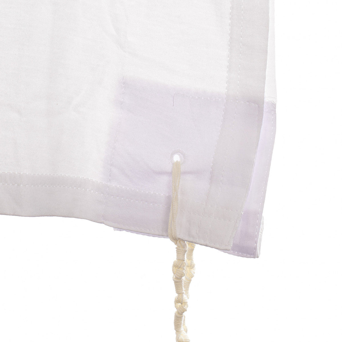 Close-up of reinforced PerfTzit corner, opening, and tied tzitzis strings