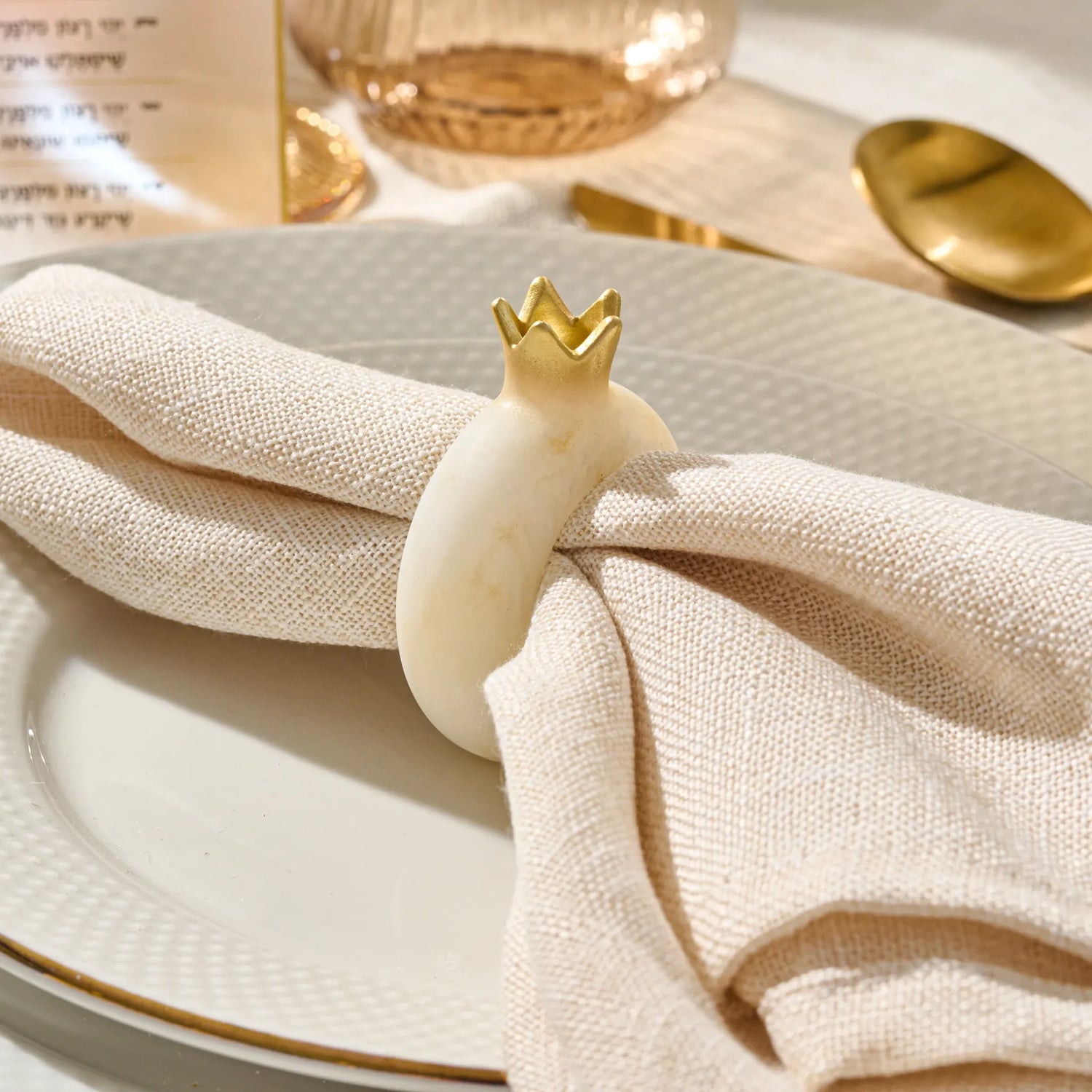 Marble-look pomegranate napkin ring holding a white cloth napkin