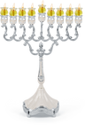 Marbleized white and silver-plated oil menorah with lit glass oil cups on a white base