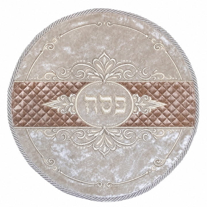 Round pale velvet matzah cover with a quilted brown band, cream ornamental embroidery and central Hebrew Pesach lettering