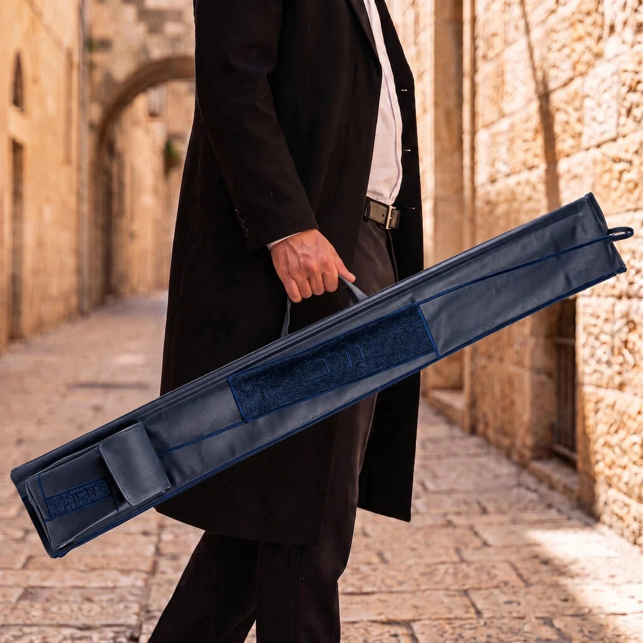 Navy Waterdale geometric lulav case with attached esrog bag carried by its handle