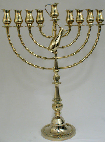 Tall brass oil menorah with tulip cups on curved segmented arms and a sculpted pitcher at the center