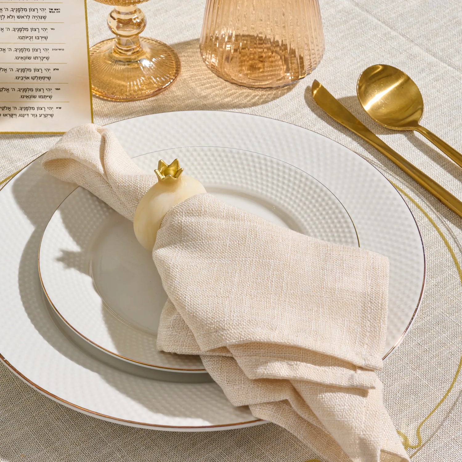 Pomegranate-shaped napkin ring securing a folded cloth napkin
