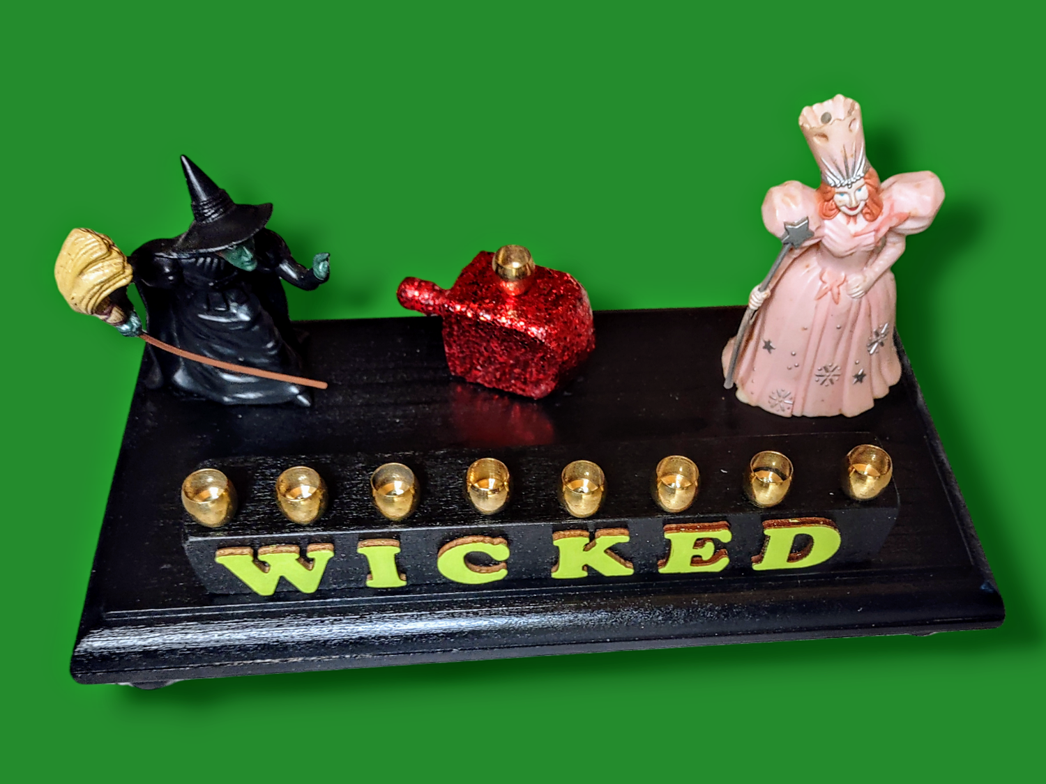 Wicked menorah — Elphaba and Glinda figures with ruby red dreidel and brass candle cups | Judaica Square Lakewood (view 3)