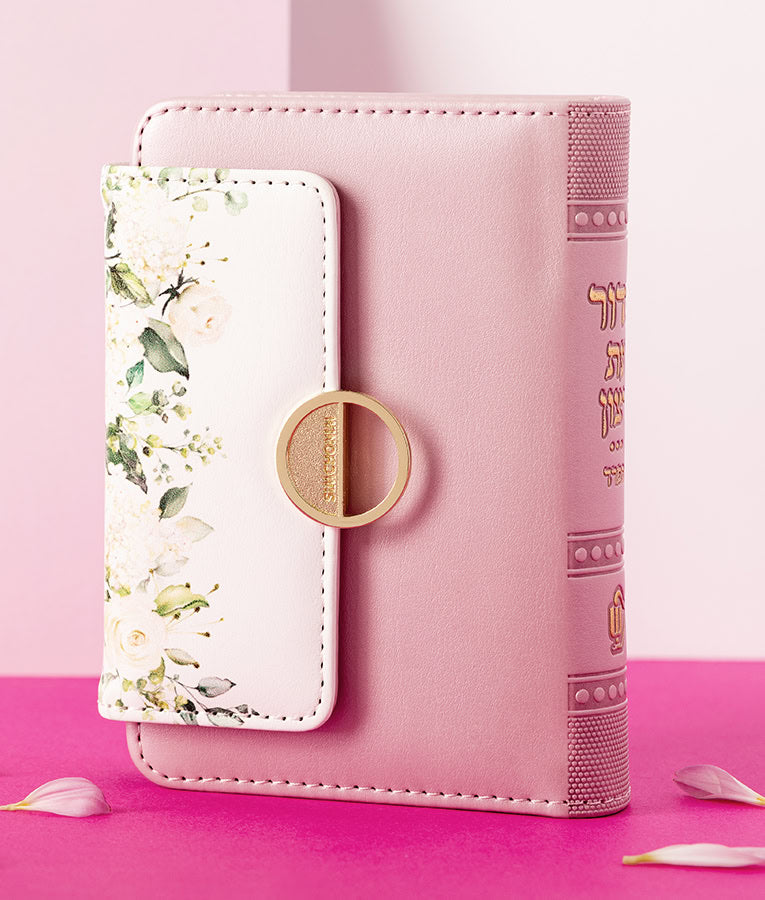 Simchonim Floral style siddur with magnetic closure in light pink, shown on a table setting