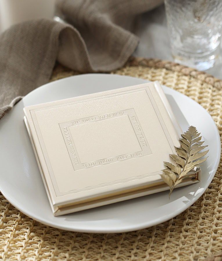 Simchonim Noam style Haggadah, shown on a table setting