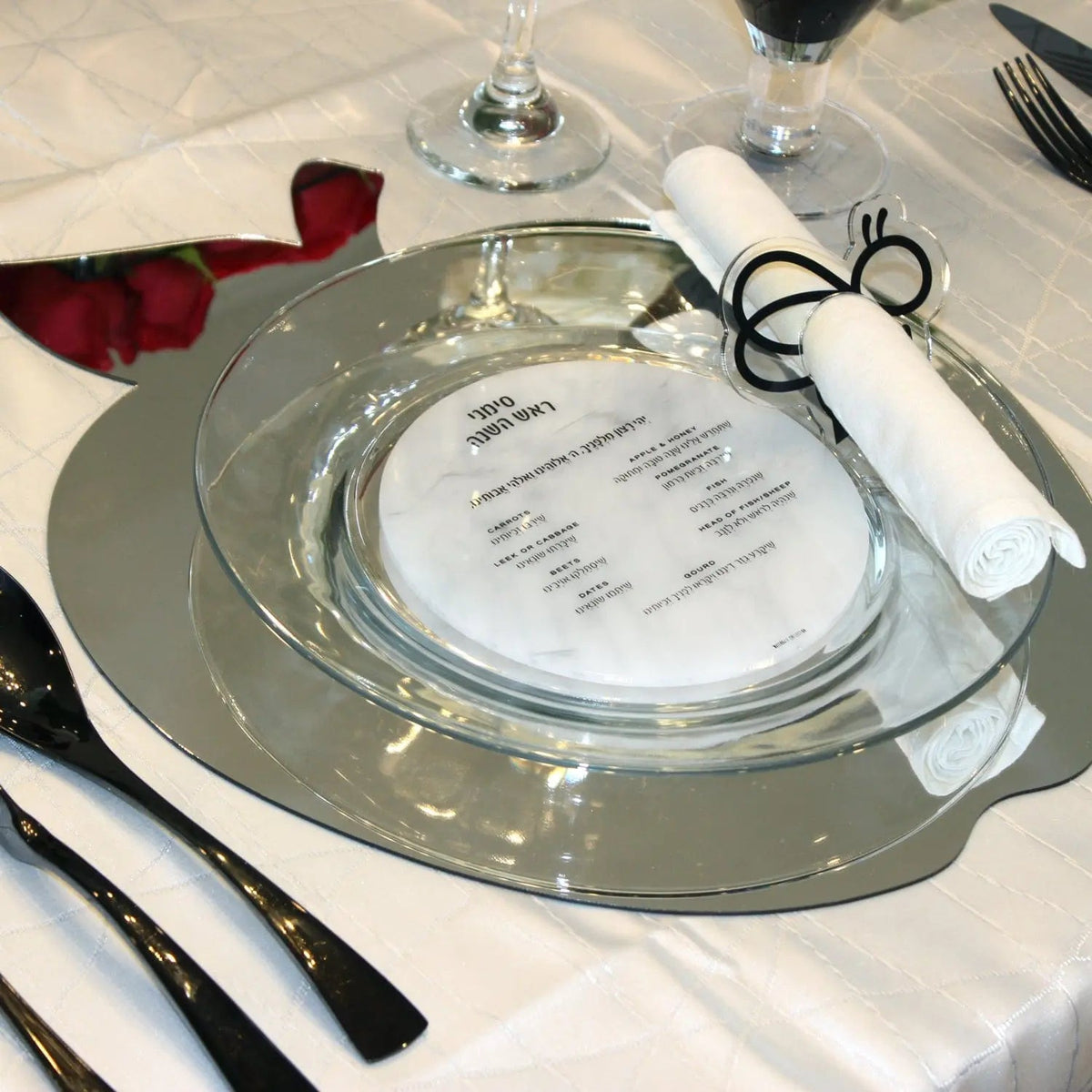 Silver Waterdale apple-shaped charger beneath a glass plate