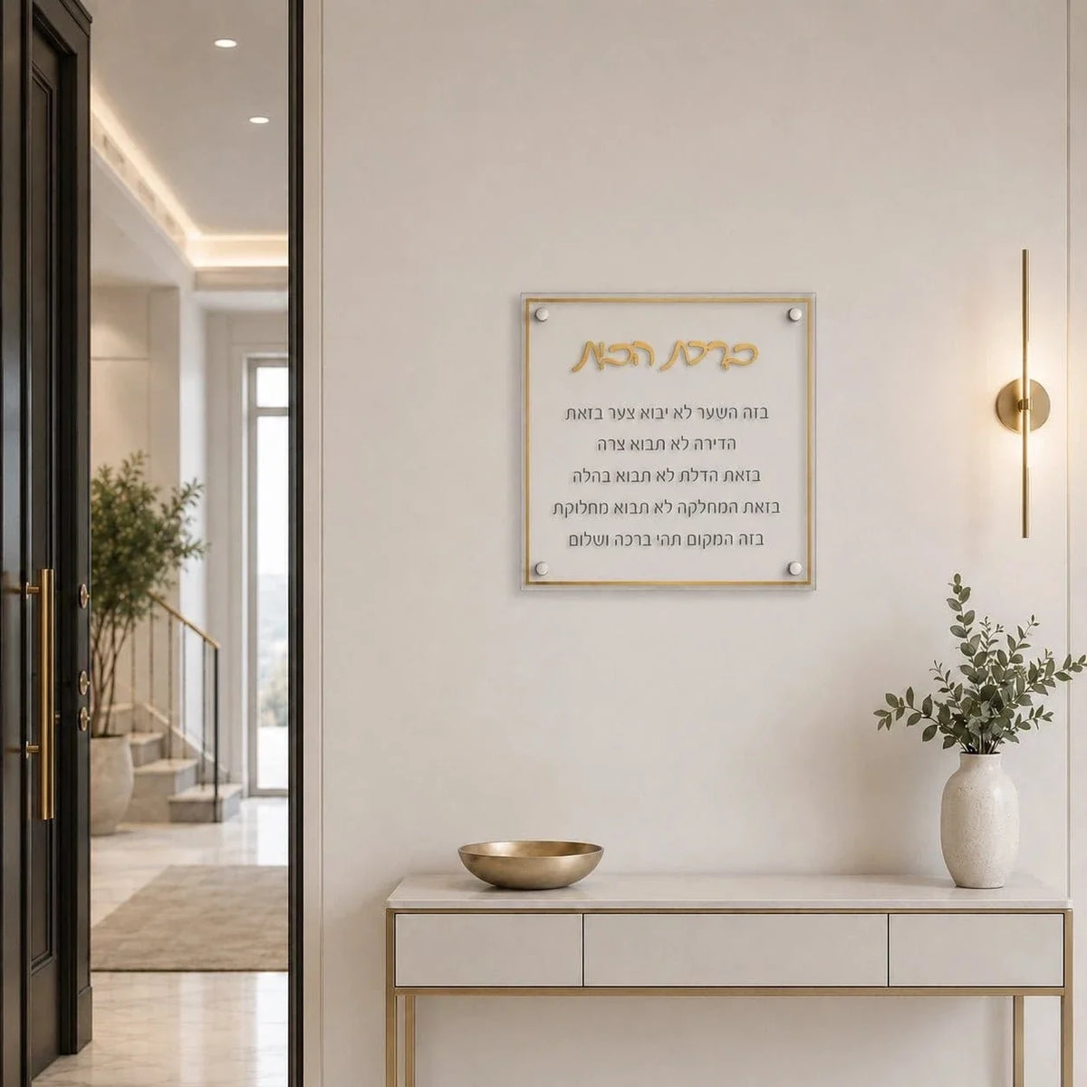 Gold Birchas Habayis hung above a console table with a vase in an entryway