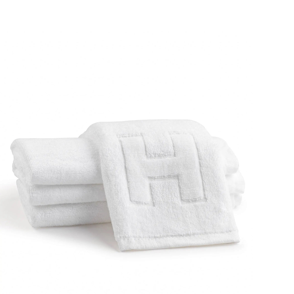 White cotton finger towel set embossed with the letter H, two towels folded
