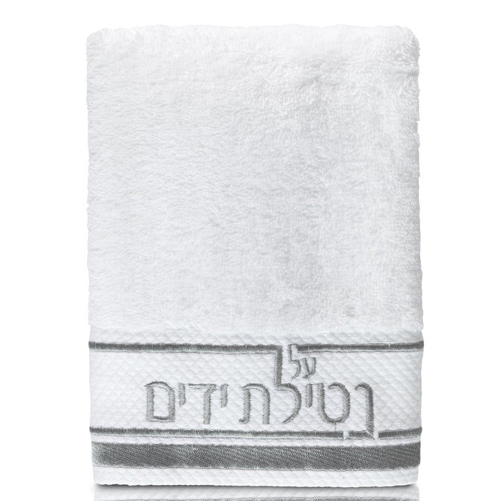 Silver-lettered Netilas Yadayim hand towel hanging on a wall hook