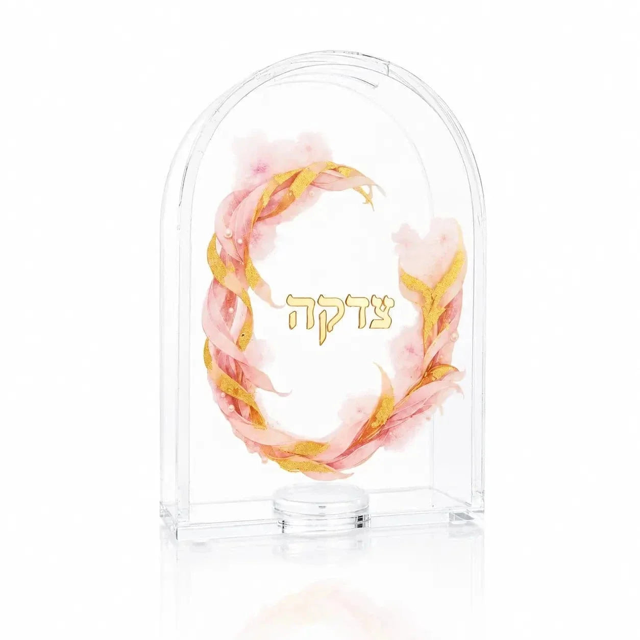 Arched lucite tzedakah box with gold Tzedakah lettering inside a pink and gold floral wreath