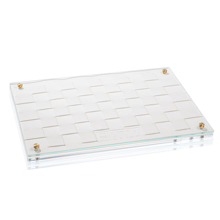 White woven leather challah board with a glass top and gold corner screws, angled view