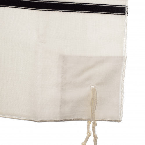 One-hole corner detail on a white wool tallis katan with black stripe